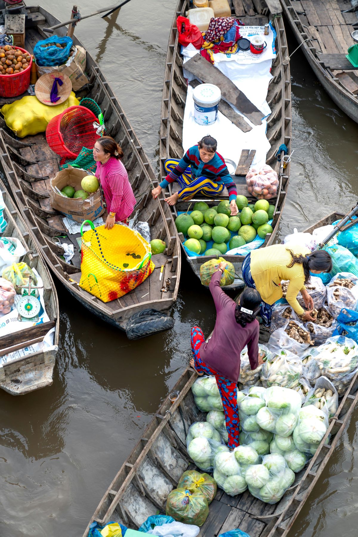 People selling fruits and vegetables from boats in floating market