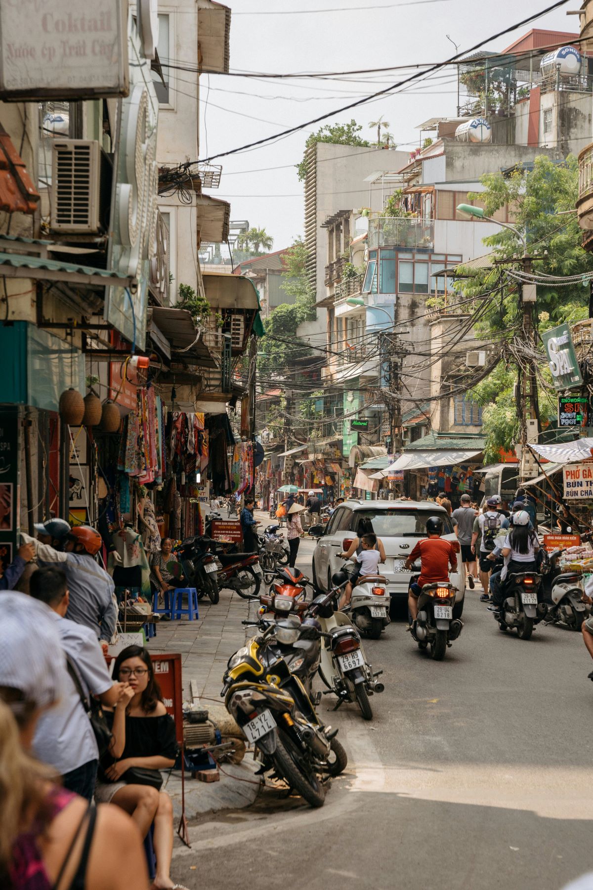 People sitting on sidewalk in Hanoi stree